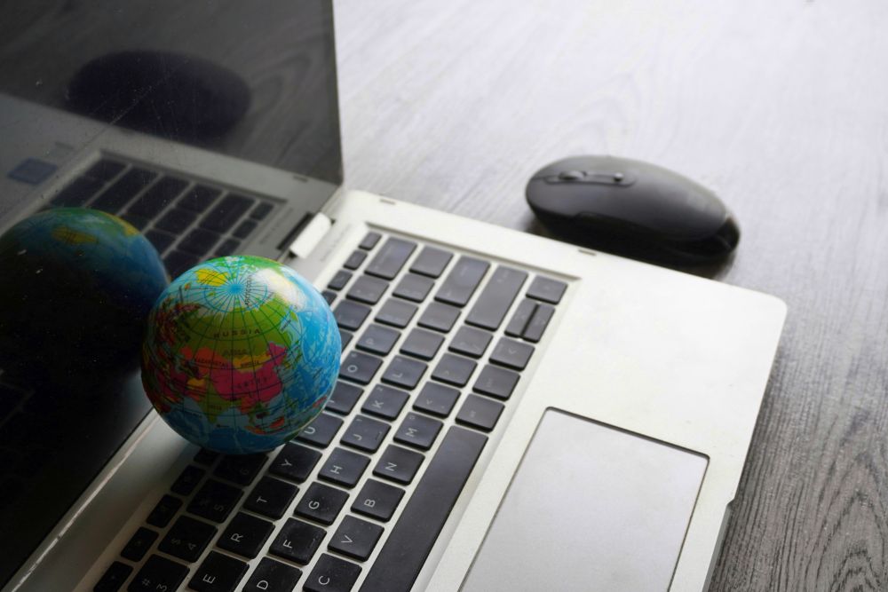 close up image of globe laptop keyboard and comput YPV6UBK